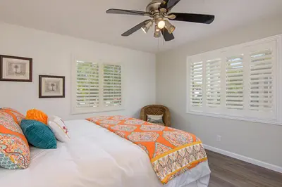 a bedroom with a bed and a ceiling fan at Ultimate Beach Bungalow - 1 block from beach - huge backyard in Carlsbad