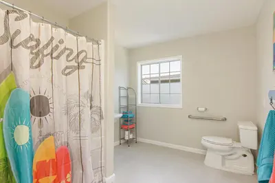 a bathroom with a shower curtain and a toilet at Ultimate Beach Bungalow - 1 block from beach - huge backyard in Carlsbad