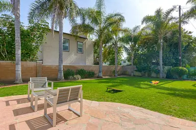 two benches sitting on a patio in front of a yard at Ultimate Beach Bungalow - 1 block from beach - huge backyard in Carlsbad