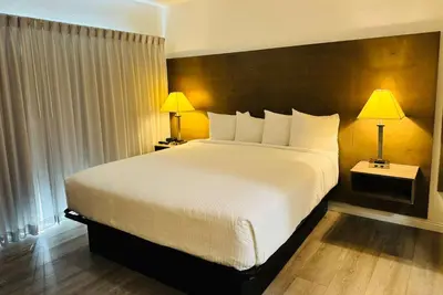 a bedroom with a large white bed with two lamps at Ramada by Wyndham San Diego Airport in San Diego