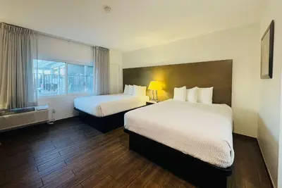 a hotel room with two beds and a window at Ramada by Wyndham San Diego Airport in San Diego