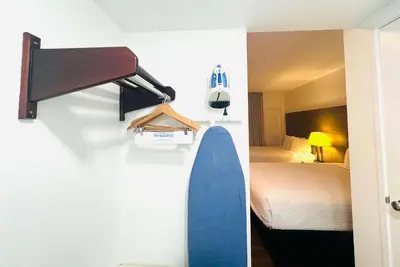 a room with a bed and a surfboard on a wall at Ramada by Wyndham San Diego Airport in San Diego