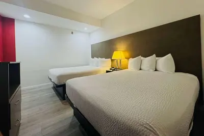 a hotel room with two beds and a lamp at Ramada by Wyndham San Diego Airport in San Diego