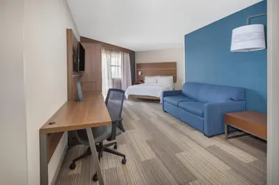a hotel room with a blue couch and a desk at Holiday Inn Express San Diego Airport-Old Town by IHG in San Diego