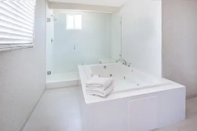 a white bathroom with a bath tub with towels at Holiday Inn Express San Diego Airport-Old Town by IHG in San Diego