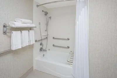 a bathroom with a tub and a shower with towels at Holiday Inn Express San Diego Airport-Old Town by IHG in San Diego