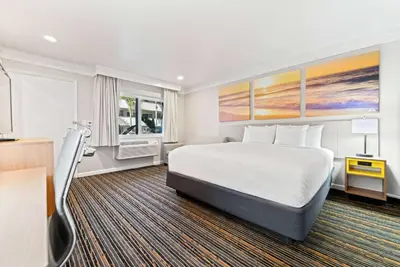 a hotel room with a large bed and a desk at Days Inn by Wyndham San Diego Hotel Circle in San Diego