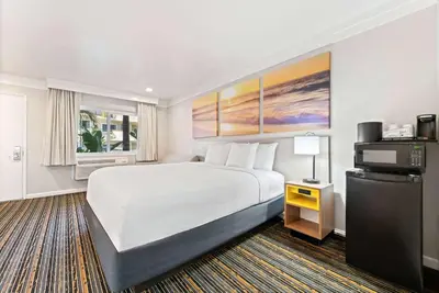 a hotel room with a bed and a television at Days Inn by Wyndham San Diego Hotel Circle in San Diego
