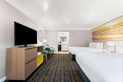 a hotel room with a bed and a flat screen tv at Days Inn by Wyndham San Diego Hotel Circle in San Diego