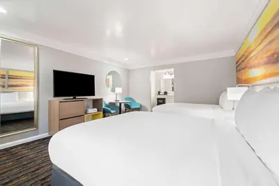 a hotel room with a large bed and a flat screen tv at Days Inn by Wyndham San Diego Hotel Circle in San Diego