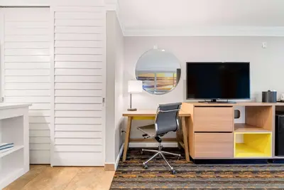 a room with a desk with a television and a chair at Days Inn by Wyndham San Diego Hotel Circle in San Diego