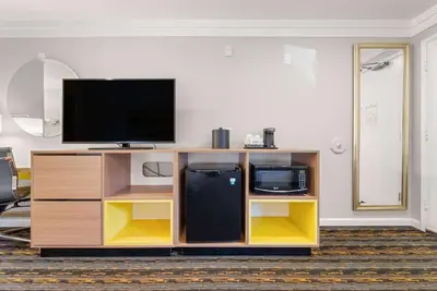 a entertainment center with a flat screen tv on top at Days Inn by Wyndham San Diego Hotel Circle in San Diego