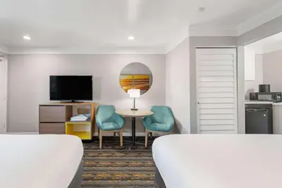 a hotel room with two beds and a table and chairs at Days Inn by Wyndham San Diego Hotel Circle in San Diego