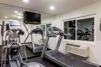 a gym with tread machines and a flat screen tv at Days Inn by Wyndham San Diego Hotel Circle in San Diego
