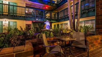 a patio with a table and chairs and a statue at Best Western Plus Dana Point Inn-by-the-Sea in Dana Point
