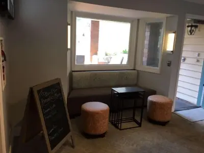 a room with a bench and two stools and a window at Best Western Plus Dana Point Inn-by-the-Sea in Dana Point
