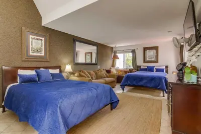 a bedroom with two beds and a living room at PACIFIC BEACH MANSION in San Diego