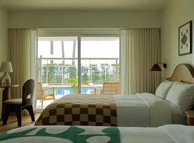 a hotel room with a bed and a view of a pool at Casa Loma Beach Hotel in Laguna Beach