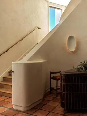 a staircase in a house with a table and a chair at Casa Loma Beach Hotel in Laguna Beach