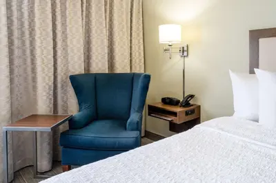 a room with a blue chair next to a bed at Hampton Inn by Hilton Irvine East - Lake Forest in Foothill Ranch