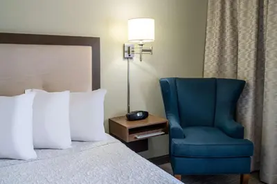 a bedroom with a bed and a blue chair at Hampton Inn by Hilton Irvine East - Lake Forest in Foothill Ranch