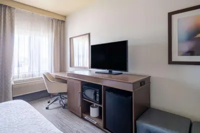 a hotel room with a desk with a flat screen tv at Hampton Inn by Hilton Irvine East - Lake Forest in Foothill Ranch