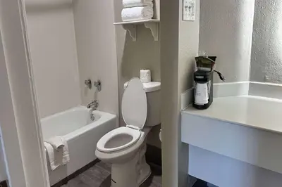 a white bathroom with a toilet and a sink at Days Inn by Wyndham San Diego Vista in Vista