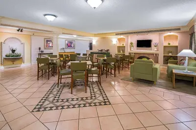 a restaurant with tables and chairs and a fireplace at Days Inn by Wyndham San Diego Vista in Vista