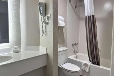 a bathroom with a toilet and a sink and a shower at Days Inn by Wyndham San Diego Vista in Vista