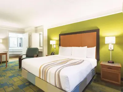 a hotel room with a large bed and a desk at La Quinta Inn by Wyndham San Diego Chula Vista in Chula Vista