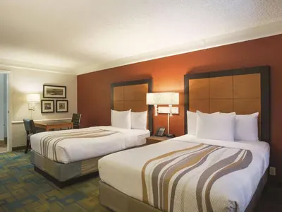 a hotel room with two beds and a desk at La Quinta Inn by Wyndham San Diego Chula Vista in Chula Vista