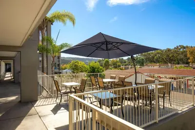 a patio with a table and an umbrella at La Quinta Inn by Wyndham San Diego - Miramar in Sabre Springs