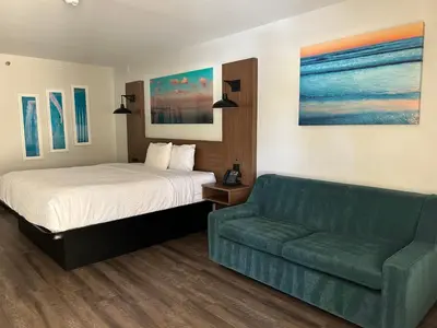 a bedroom with a bed and a couch at La Quinta Inn by Wyndham San Diego - Miramar in Sabre Springs