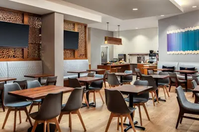 a restaurant with wooden tables and chairs and a kitchen at San Diego Marriott La Jolla in San Diego