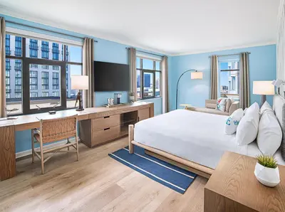 a bedroom with a large bed and a desk with a computer at Margaritaville Hotel San Diego Gaslamp Quarter in San Diego