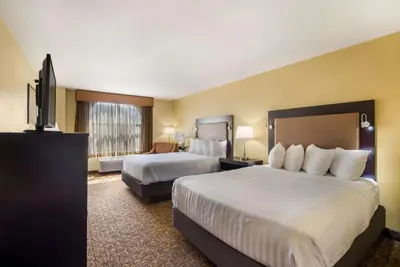 a hotel room with two beds and a flat screen tv at Best Western Escondido Hotel in Escondido