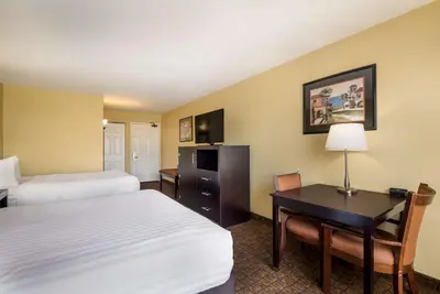 a hotel room with two beds and a desk at Best Western Escondido Hotel in Escondido