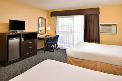 a hotel room with two beds and a desk at Dana Point Marina Inn in Dana Point
