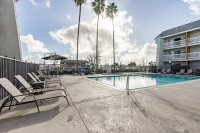 a swimming pool with lounge chairs next to a building at Dana Point Marina Inn in Dana Point
