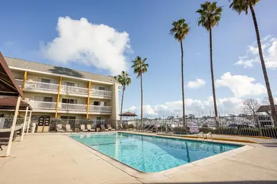 a swimming pool in front of a hotel with palm trees at Dana Point Marina Inn in Dana Point