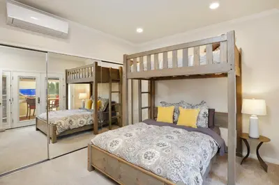 a bedroom with two bunk beds and a mirror at 416 Dahlia in Newport Beach