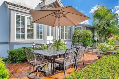 a table and chairs with an umbrella on a patio at 416 Dahlia in Newport Beach