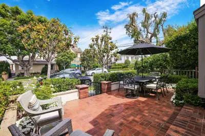 a patio with a table and chairs and an umbrella at 416 Dahlia in Newport Beach