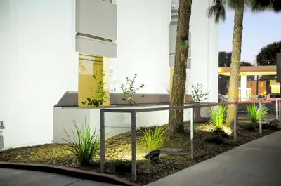 a table in front of a building with palm trees at Hercor Hotel - Urban Boutique in Chula Vista