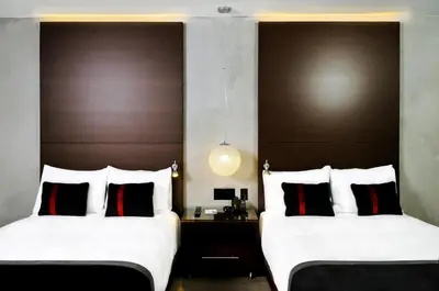 two beds sitting next to each other in a room at Hercor Hotel - Urban Boutique in Chula Vista