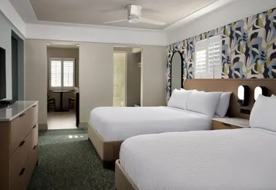 a hotel room with two beds and a television at Diamond Head Inn in San Diego