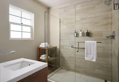 a bathroom with a sink and a glass shower at Diamond Head Inn in San Diego