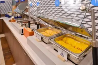 a counter in a store with trays of food at Holiday Inn Express La Mesa Near SDSU by IHG in La Mesa