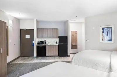 a room with a bed and a kitchen with a refrigerator at Holiday Inn Express La Mesa Near SDSU by IHG in La Mesa
