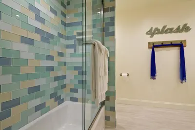 a bathroom with a tub and a glass shower at Ocean Palms Beach Resort in Carlsbad